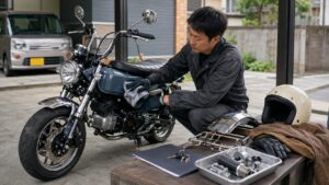 バイク査定前に日本人男性がガレージで車体を軽く清掃している様子